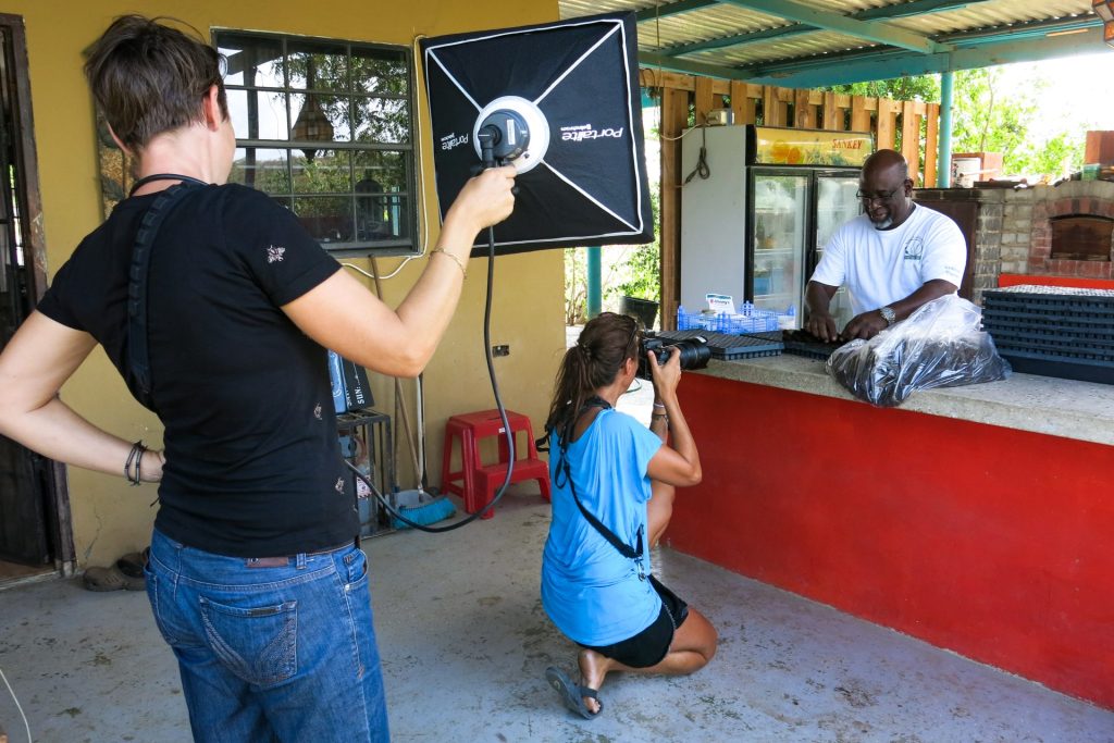 a man does an action and a woman takes a picture of it